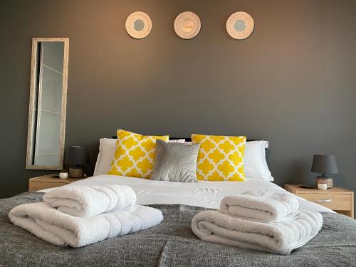 een slaapkamer met een bed met handdoeken erop bij Tailor That Property - Chelsea House in Milton Keynes