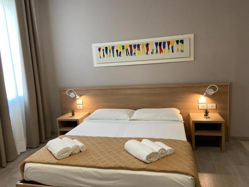 a bedroom with a large bed with two towels on it at Locanda Damaro in Vicenza