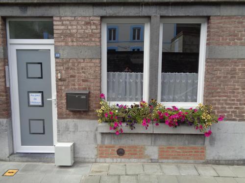 a building with a window with flowers in a window box at AU PIED DE L'ABBAYE DE LEFFE in Dinant