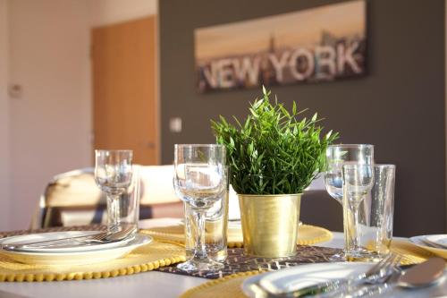 a table with glasses and a potted plant on it at Tailor That Property - Chelsea House in Milton Keynes