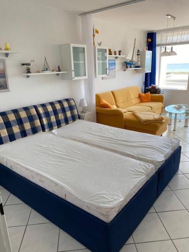 a large bed in a room with a couch at Inselglueck in Burgtiefe auf Fehmarn 