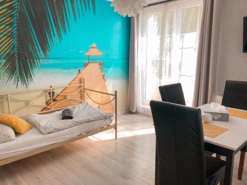 1 dormitorio con 1 cama con un mural de playa en la pared en Hostel Przed Świtem, en Gorzów Wielkopolski