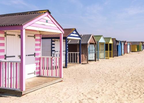 a row of colourful beach huts on the beach at The Harbour Retreat in Birdham