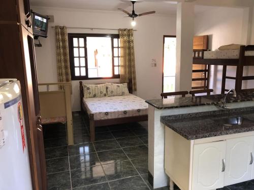 sala de estar con cama y sofá en una habitación en Kitnets Park Verde, en Peruíbe