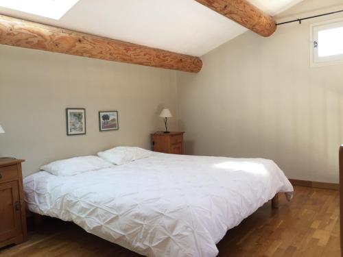 a bedroom with a large white bed and a window at AU PIED DU VENTOUX in Flassan