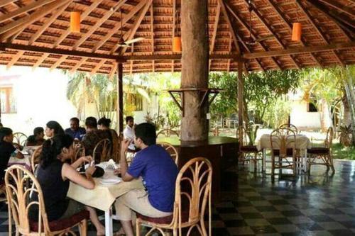 un grupo de personas sentadas en una mesa en un restaurante en BBN Serviced Apartment, en Calangute