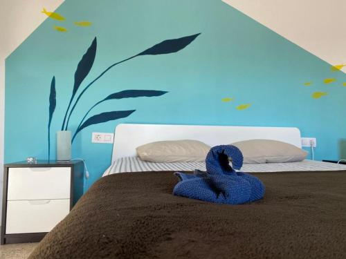 a bedroom with a bed with a blue wall at joyhouse in Teguise