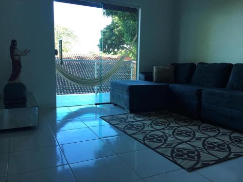 a living room with a blue couch and a rug at Alter do Chão Casa de praia nobre beira mar in Alter do Chao