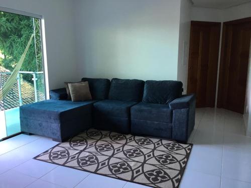 a blue couch in a living room with a rug at Alter do Chão Casa de praia nobre beira mar in Alter do Chao