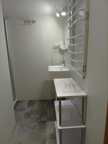 a small white bathroom with a sink and a counter at Glemmy Appartements inkl Sommercard in Viehhofen