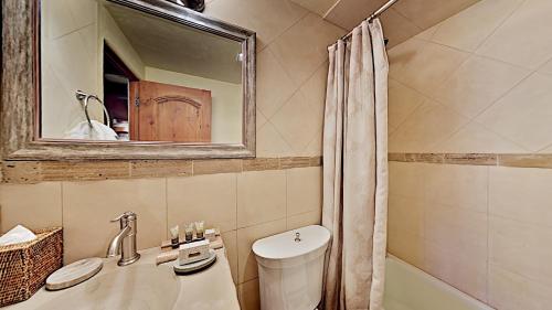 a bathroom with a sink and a toilet and a mirror at Timberline Condominiums 2 Bedroom Premier Unit C1D in Snowmass Village