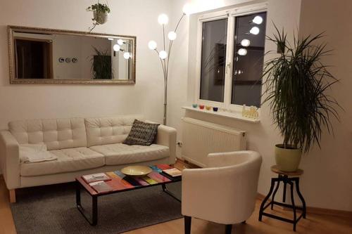 a living room with a white couch and a table at 3-Raum Apartment auf der DOM-Insel in Brandenburg an der Havel