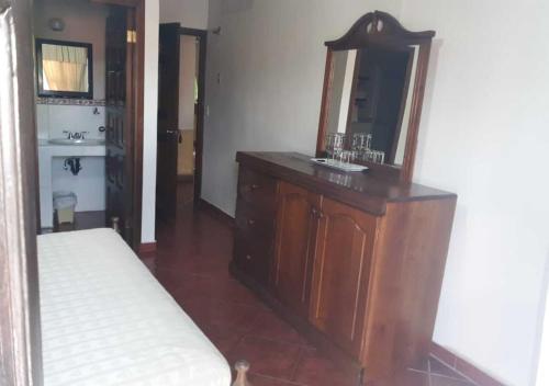 a bedroom with a wooden dresser with a mirror at Hotel Acropolis Maya in Copan Ruinas