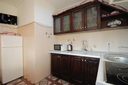 a kitchen with a sink and a microwave at Садиба АнноМарі - відпочинок в Карпатах котедж Яремче in Yaremche