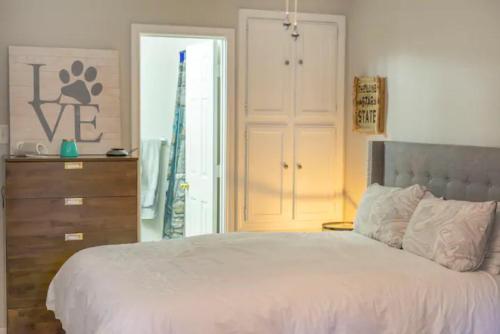 a bedroom with a bed and a dresser and a closet at Morse Cottage in Houston