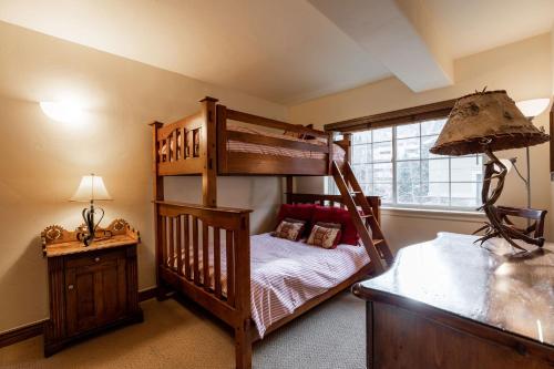 a bedroom with a bunk bed and a desk at 9 Vail Road Vail Village 2 to 4 Bedrooms by Vail Realty in Vail