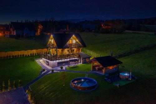 an aerial view of a large house with a boat in the yard at Domek w górach DeLuxe sauna,jacuzzi,basen,hot tub-Nowy Targ blisko Białka ,Zakopane in Nowy Targ