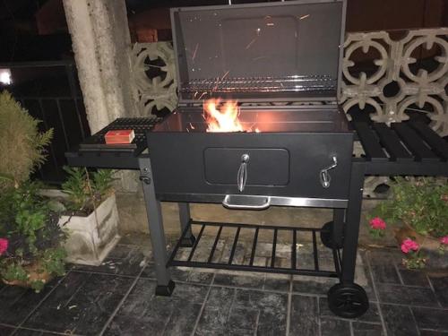 a grill with a fire in it on a patio at Confortable departamento entero in Belén de Escobar