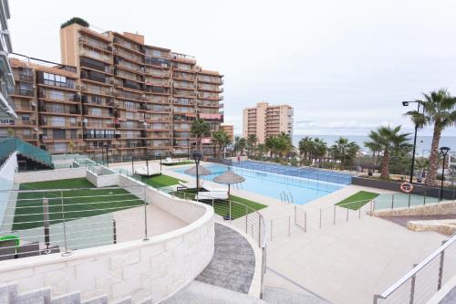een uitzicht op het zwembad in een resort met gebouwen bij White luxury apartment in Arenales del Sol