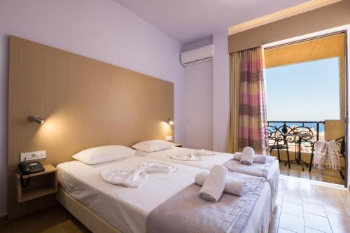a hotel room with two beds with towels on them at Atlantis Hotel in Karpathos Town