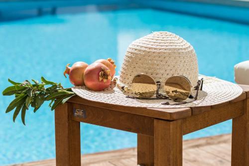 a hat and fruit on a table next to a pool at Atlantis Hotel in Karpathos Town
