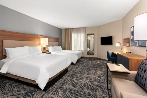 a hotel room with two beds and a couch at Candlewood Suites Sumner Puyallup Area by IHG in Sumner