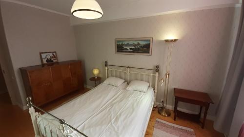 um quarto com uma cama, uma mesa e um candeeiro em Majakovski Family Suite em Sillamäe