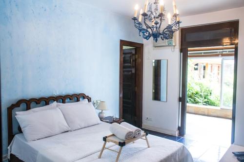 a bedroom with a bed with a chair and a chandelier at Pernambuco Club House in Guarujá