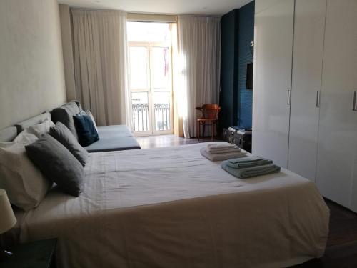 a bedroom with a large bed with towels on it at Lovely Apartment @ Aveiro's Downtown in Aveiro