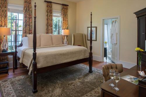 a bedroom with a four poster bed and a table at The Addison on Amelia in Fernandina Beach