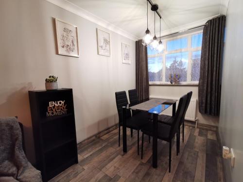 uma sala de jantar com uma mesa e cadeiras e uma janela em Palaz 2 - 2 Bedroom Flat em Edmonton