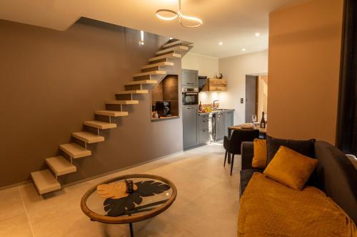 a living room with a staircase and a couch at Domaine de l'Angélique - Loft avec SPA privatif - Marais poitevin entre Niort et La Rochelle in Arçais