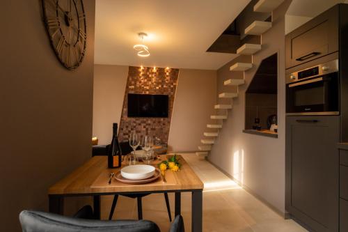 cocina y comedor con mesa y escaleras en Domaine de l'Angélique - Loft avec SPA privatif - Marais poitevin entre Niort et La Rochelle en Arçais