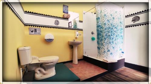 a bathroom with a toilet and a shower at Hostal Yakumama in Cuenca