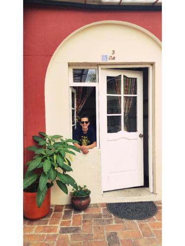 a man sitting at the door of a house at Hostal Yakumama in Cuenca
