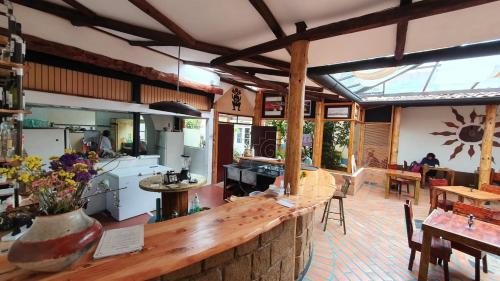 a large kitchen and dining room with a counter and tables at Hostal Yakumama in Cuenca