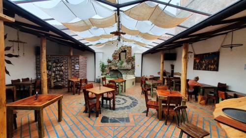 a large room with tables and chairs and a fireplace at Hostal Yakumama in Cuenca