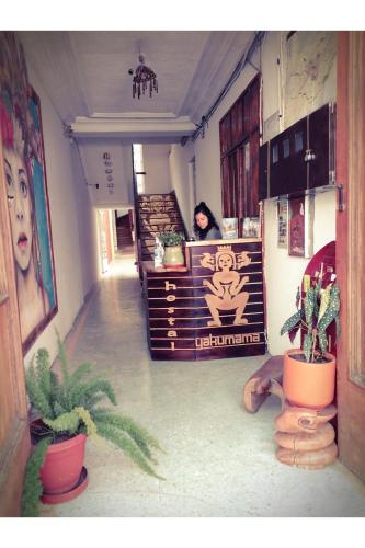 a woman is standing in a room with plants at Hostal Yakumama in Cuenca