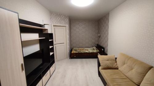 ein Wohnzimmer mit einem Sofa und einem Bett in der Unterkunft Уютные апартаменты 1 комн квартира, ЖК Губернский in Krasnodar