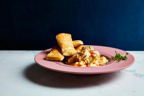 a pink plate with food on a table at Kimpton Hotel Fontenot by IHG in New Orleans