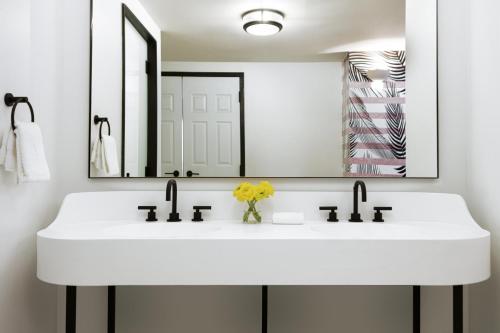a bathroom with a white sink and a mirror at Kimpton Hotel Fontenot by IHG in New Orleans