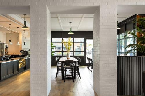 a kitchen and dining room with a table and chairs at Kimpton Hotel Fontenot by IHG in New Orleans