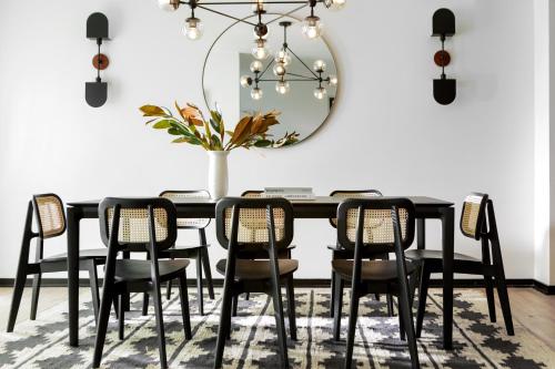 a dining room table with chairs and a mirror at Kimpton Hotel Fontenot by IHG in New Orleans