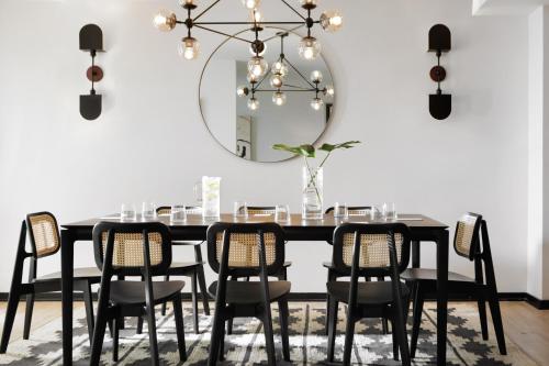 a dining room with a black table and chairs and a mirror at Kimpton Hotel Fontenot by IHG in New Orleans