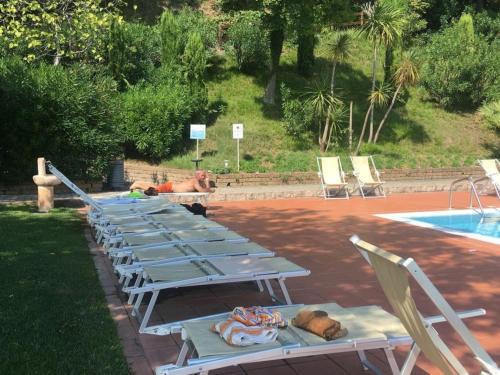 uma fila de espreguiçadeiras azuis ao lado de uma piscina em Belvilla by OYO Appartment DaFinzi em Prevalle