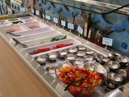 a buffet with bowls of food on a counter at Atlantis Hotel in Karpathos Town