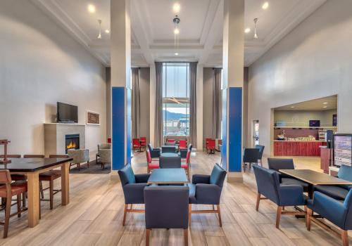 a waiting room with tables and chairs and a fireplace at Holiday Inn Express Hotel & Suites Minden by IHG in Minden