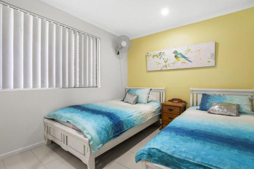 A bed or beds in a room at Golden Shores Unit 1 21 Landsborough Parade
