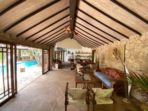 uma sala de estar com tecto em madeira e uma piscina em Anfiteatro Tropical em Búzios
