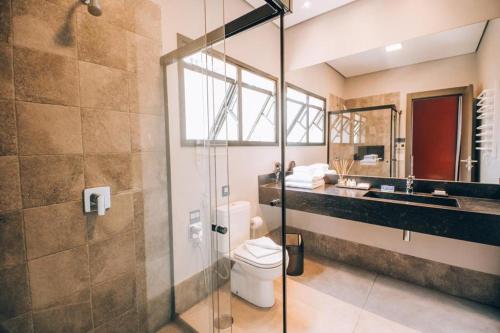 uma casa de banho com um chuveiro, um WC e um lavatório. em Villa Amistà Campos do Jordão em Campos do Jordão